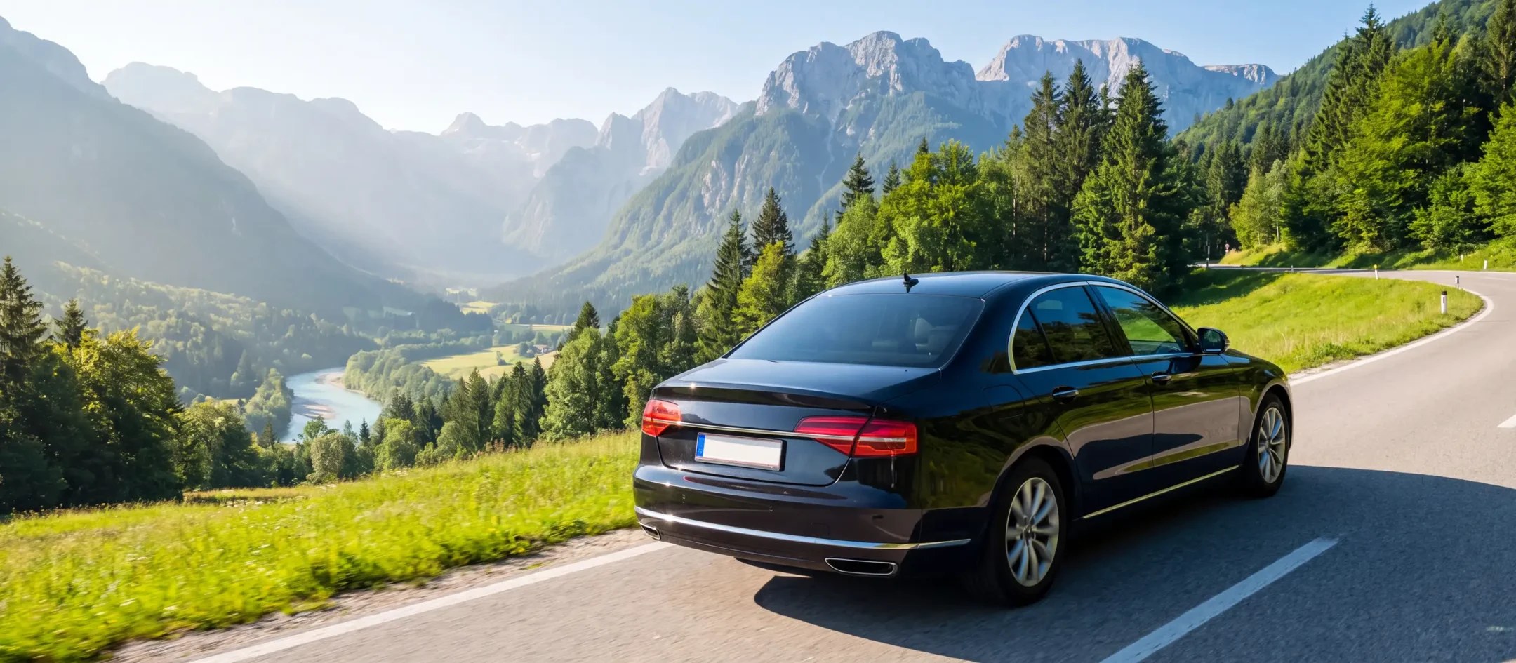 A dark vehicle on a winding Slovenian road between trees
